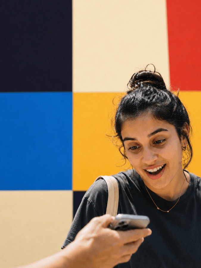 An attendee smiling while checking her phone between sessions