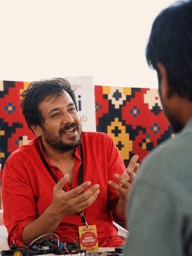 A Bitmela crew member with a Crew Support lanyard talking to an attendee